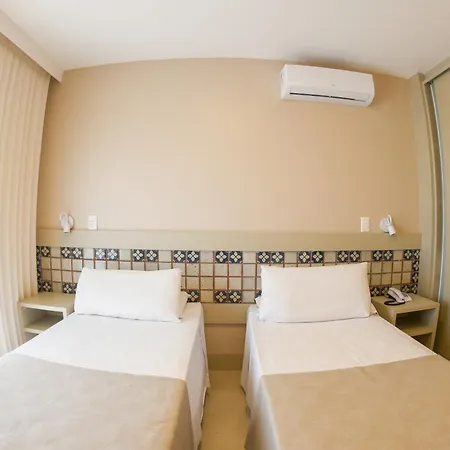 Costao Do Santinho Resort All Inclusive Florianópolis Habitación foto This is a bright, clean, and minimalist photo of a hotel room featuring two twin beds.

Here's a detailed description:

**Setting and Atmosphere:**
The room has a very neutral and airy feel, with light-colored walls (a pale beige or cream). The natur
