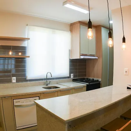 Costao Do Santinho Resort All Inclusive Florianópolis Habitación foto This is a bright, modern kitchen featuring a clean and contemporary design.

**Key features of the photo include:**

*   **Kitchen Area:** The main working area has sleek, brown/gray tiled backsplash and matching lower cabinetry. A stainless steel si