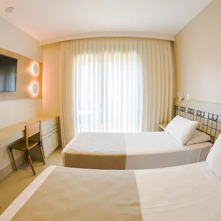 Costao Do Santinho Resort All Inclusive Florianópolis Habitación foto This is a photo of a bright, modern, and cozy hotel or guest room.

The room features two single beds, dressed in crisp white and beige/tan linens. One bed is partially visible in the foreground, while the other is positioned further back.

A large w